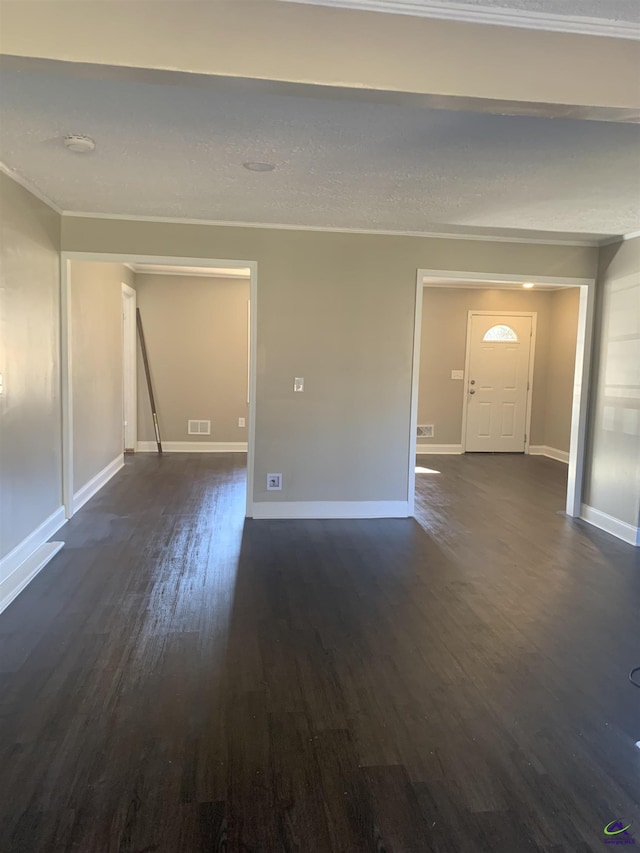 empty room with dark hardwood / wood-style flooring and crown molding