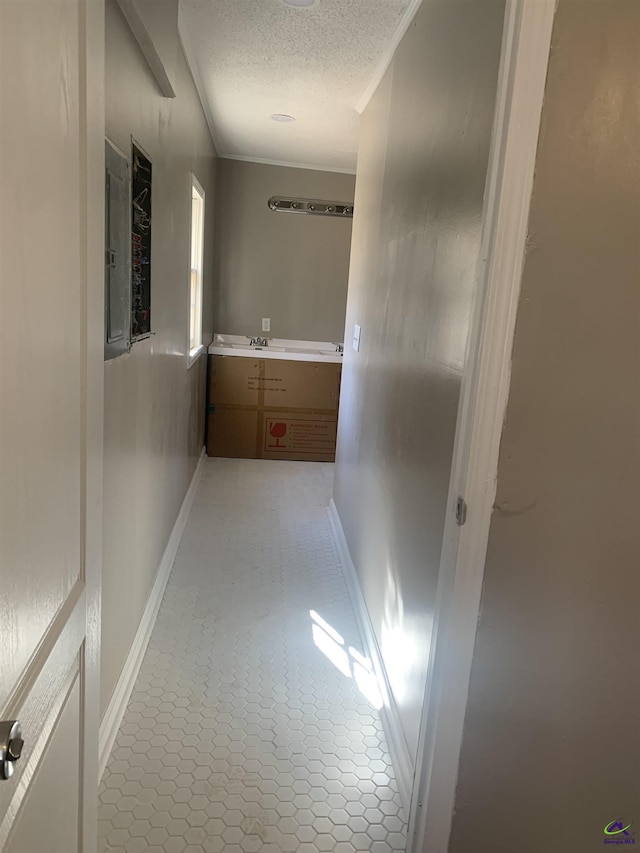 corridor with crown molding and a textured ceiling