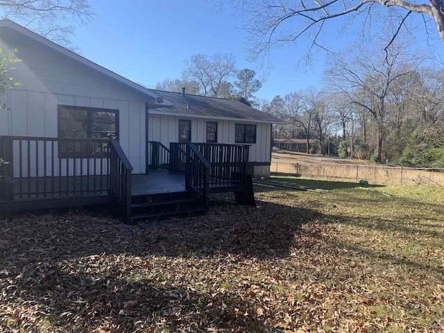 back of house featuring a wooden deck and a lawn