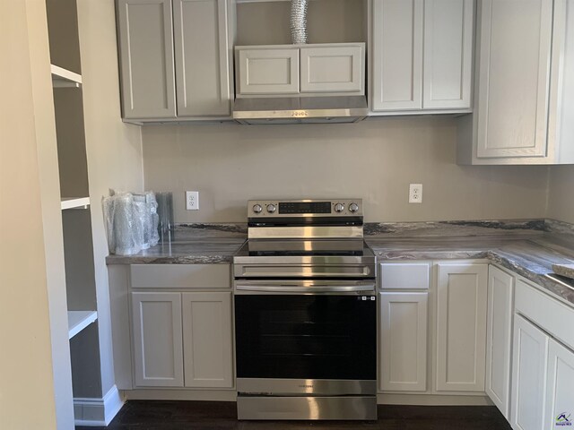 kitchen featuring white cabinetry, light stone counters, and electric range