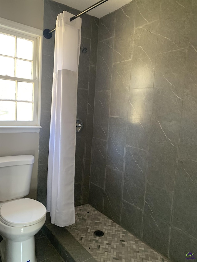 bathroom with walk in shower, toilet, and tile patterned flooring