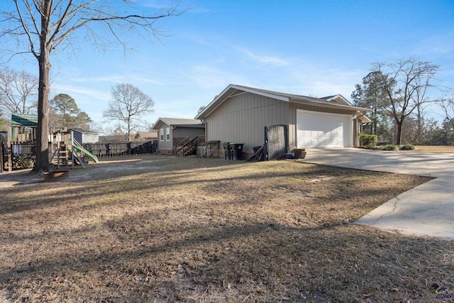 view of side of property with a garage, a playground, and a yard