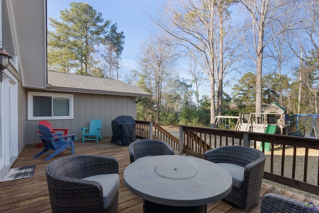 wooden terrace featuring a playground and area for grilling