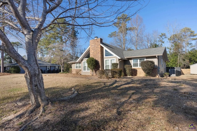 view of side of home with a lawn and central AC