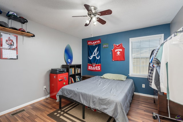 bedroom featuring a textured ceiling, ceiling fan, and dark wood-type flooring