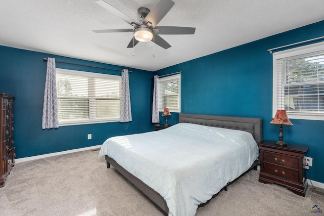 carpeted bedroom with ceiling fan and a textured ceiling