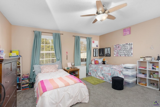 carpeted bedroom featuring ceiling fan and multiple windows