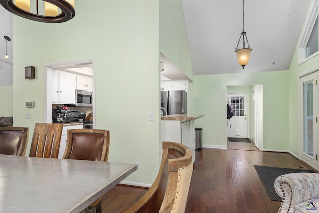 dining area featuring vaulted ceiling and dark hardwood / wood-style floors