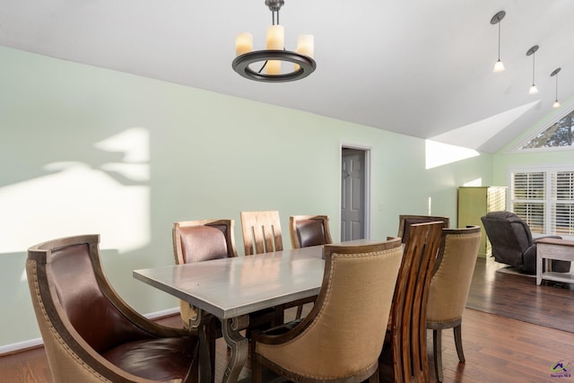 dining room featuring an inviting chandelier, vaulted ceiling, and dark hardwood / wood-style floors