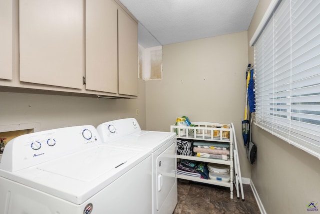 washroom featuring a textured ceiling, cabinets, and washing machine and clothes dryer