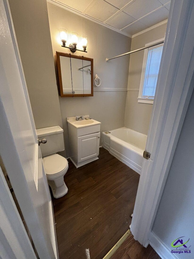 bathroom featuring a tub to relax in, toilet, wood-type flooring, vanity, and ornamental molding