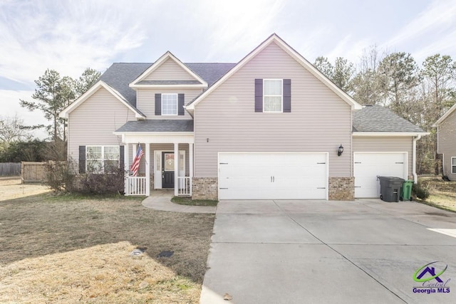 view of front property with a front yard, covered porch, and a garage