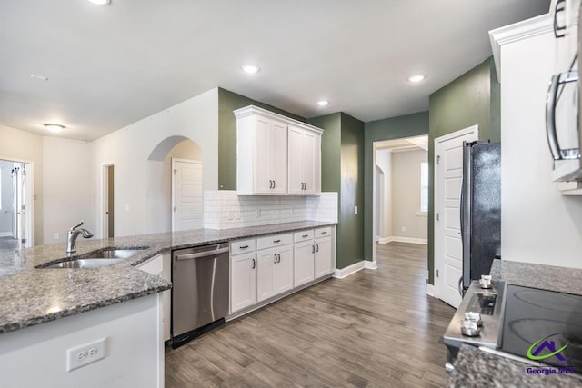 kitchen with white cabinets, dishwasher, black refrigerator, stovetop, and dark wood-type flooring