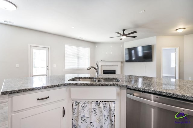 kitchen with dishwasher, ceiling fan, sink, white cabinetry, and stone countertops