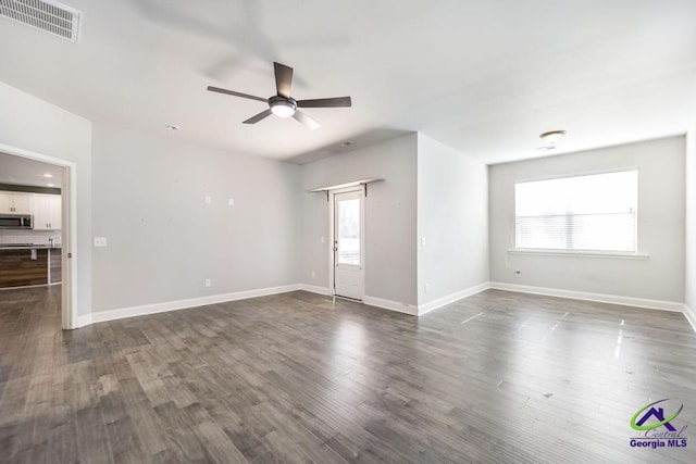 empty room with dark wood-type flooring and ceiling fan