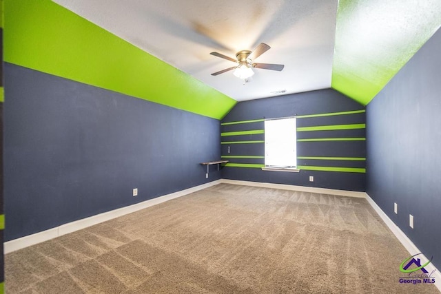 carpeted empty room featuring lofted ceiling and ceiling fan