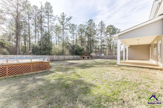 view of yard with a swimming pool side deck and a shed