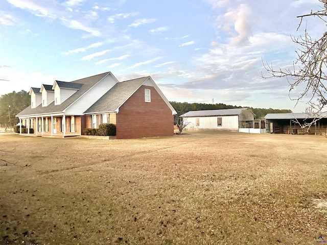 view of side of home with a porch and a yard