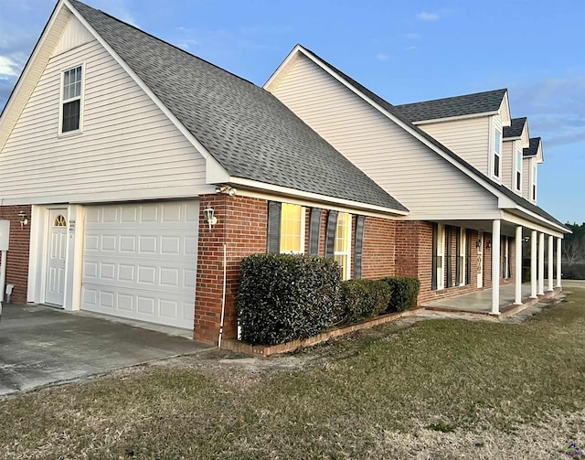 view of side of home featuring a lawn and a garage