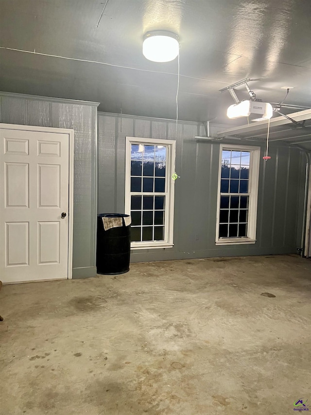 garage with wood walls and a garage door opener