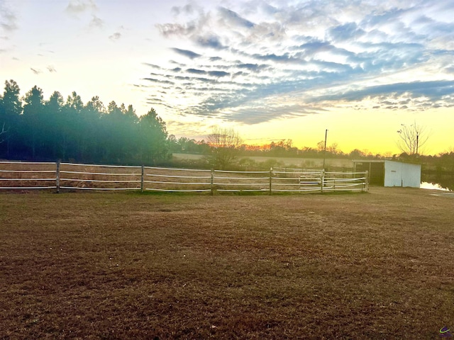 yard at dusk with a rural view