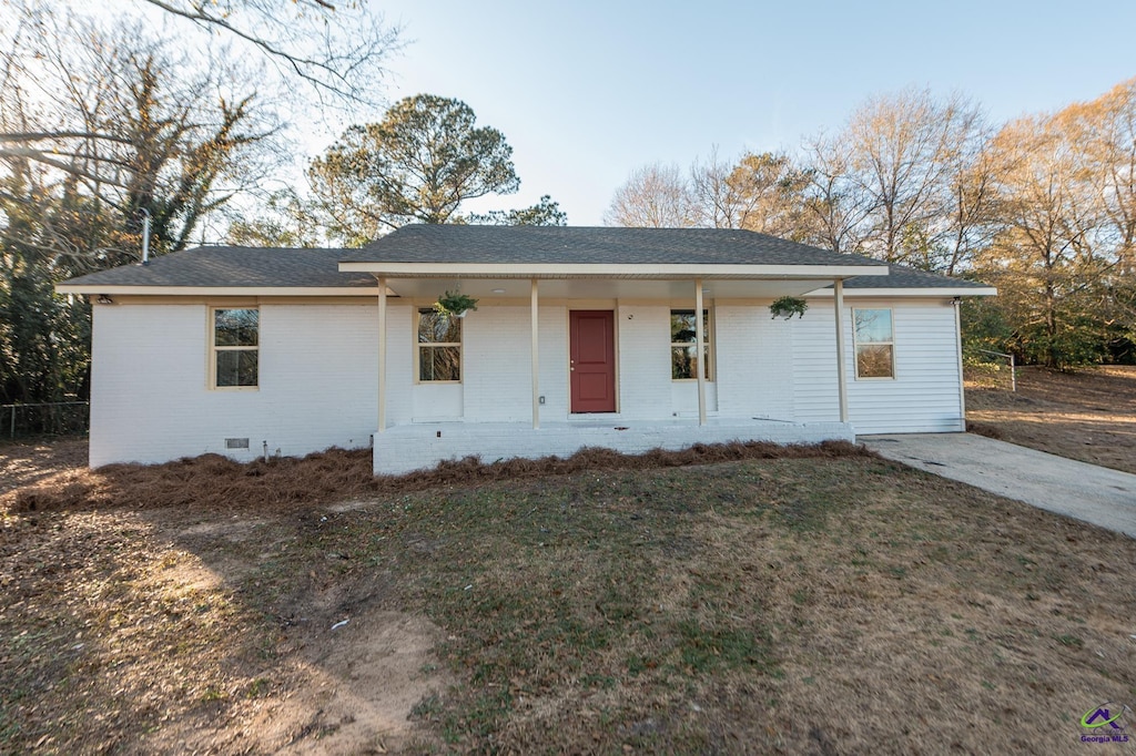 ranch-style house with a porch and a front lawn