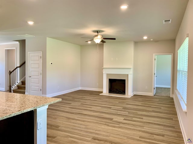 unfurnished living room with light wood-type flooring and ceiling fan