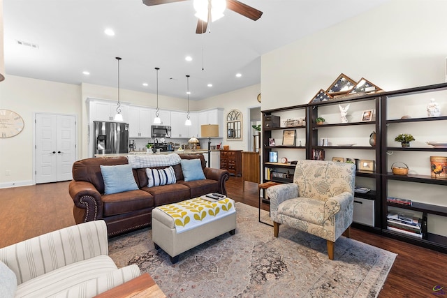 living room featuring ceiling fan and dark hardwood / wood-style flooring