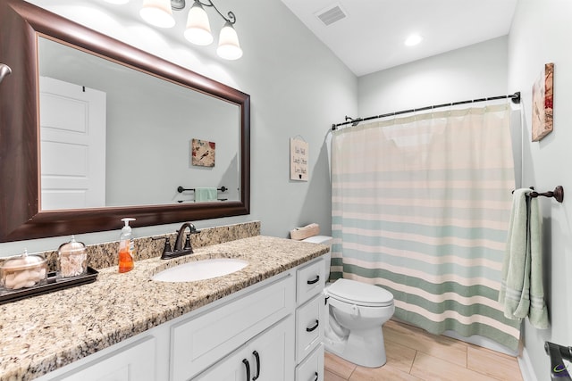 bathroom featuring vanity, a shower with shower curtain, and toilet