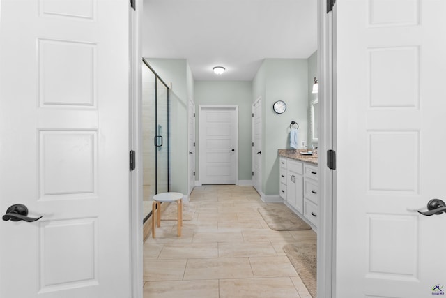 bathroom with an enclosed shower, vanity, and tile patterned flooring