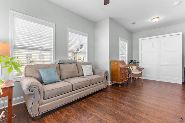 living room featuring ceiling fan and dark hardwood / wood-style flooring