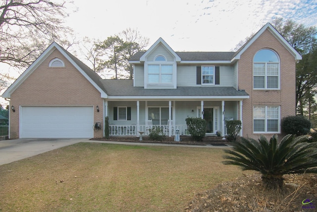 view of front of property with a porch, a front lawn, and a garage