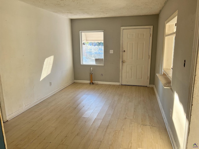 entryway with a textured ceiling and light hardwood / wood-style flooring