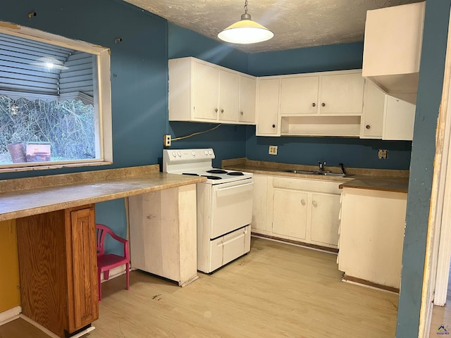 kitchen featuring decorative light fixtures, white cabinets, white range with electric stovetop, and sink