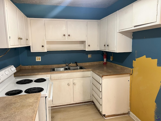 kitchen featuring sink, electric stove, light hardwood / wood-style floors, and white cabinetry