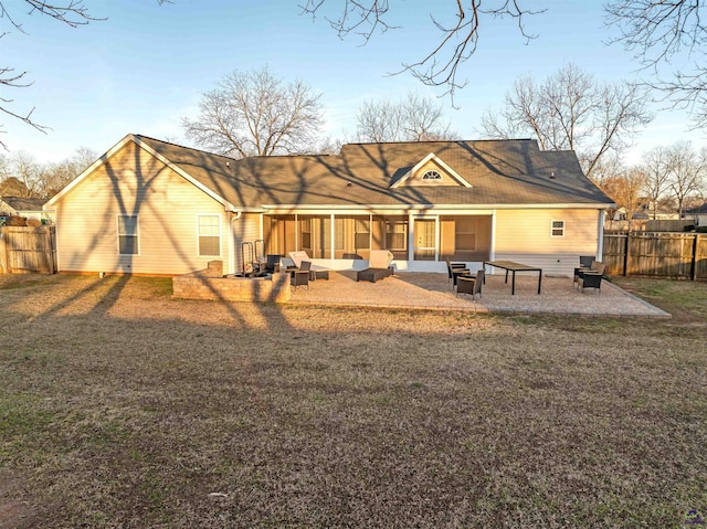 back of property with a yard and a patio