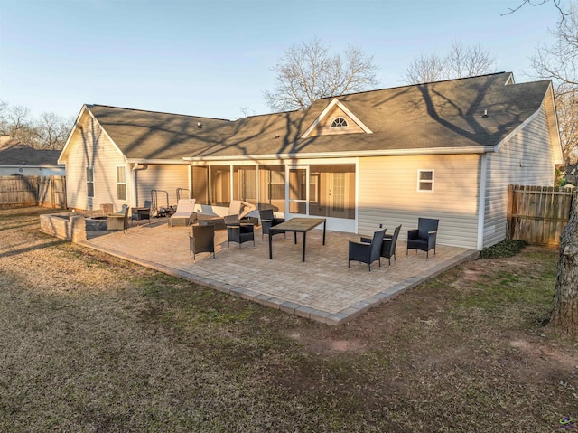 rear view of house featuring a sunroom and a patio