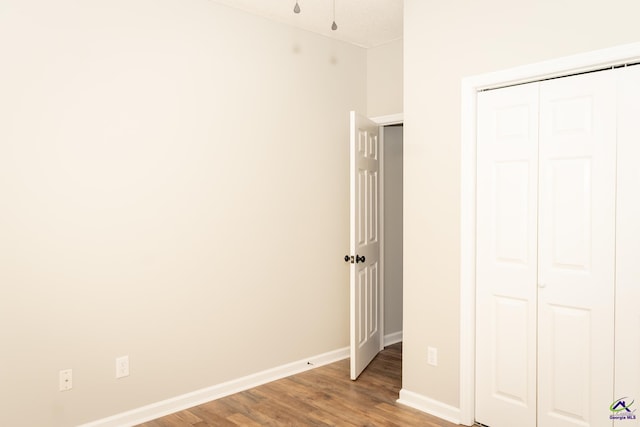 unfurnished bedroom with a closet and hardwood / wood-style floors