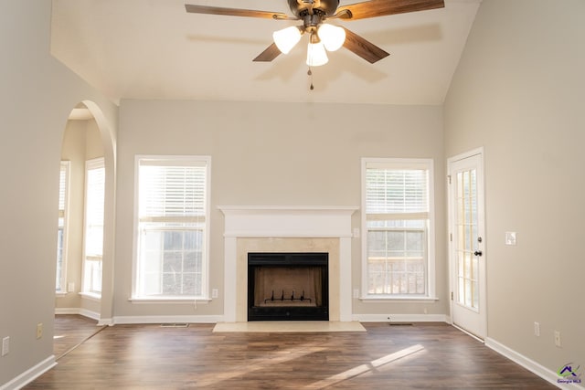 unfurnished living room with ceiling fan, lofted ceiling, a fireplace, and hardwood / wood-style flooring