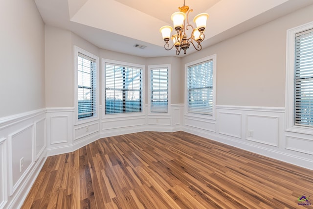 unfurnished room with a chandelier and wood-type flooring