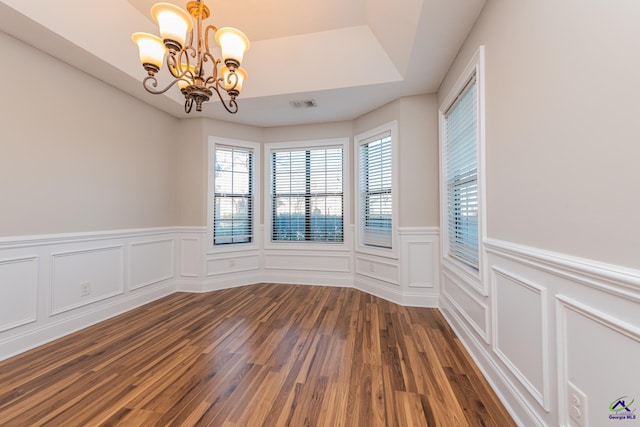 spare room featuring dark hardwood / wood-style flooring and a notable chandelier