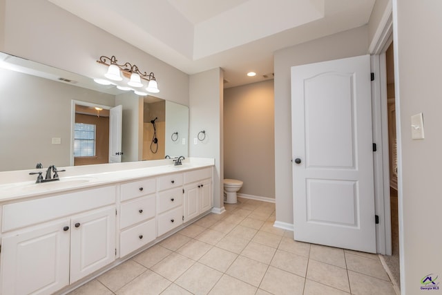 bathroom featuring a raised ceiling, vanity, and tile patterned flooring