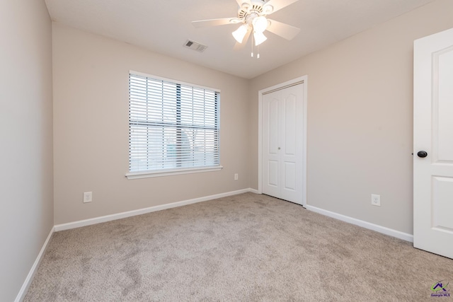 unfurnished bedroom with ceiling fan, light colored carpet, and a closet