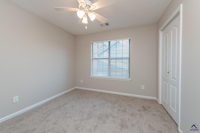 carpeted spare room with ceiling fan