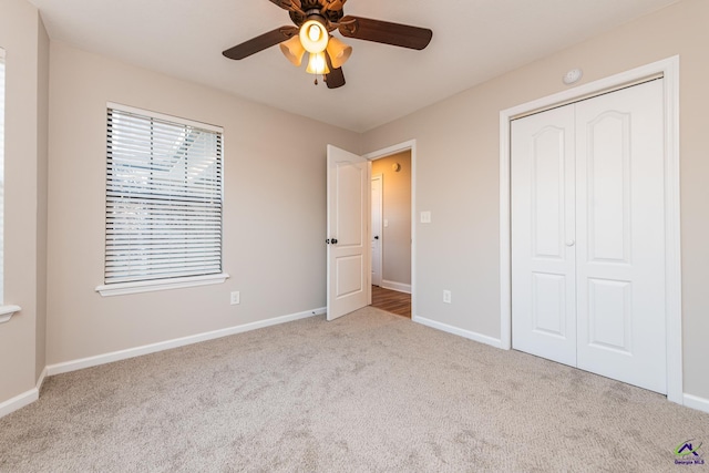 unfurnished bedroom featuring ceiling fan, a closet, and light carpet