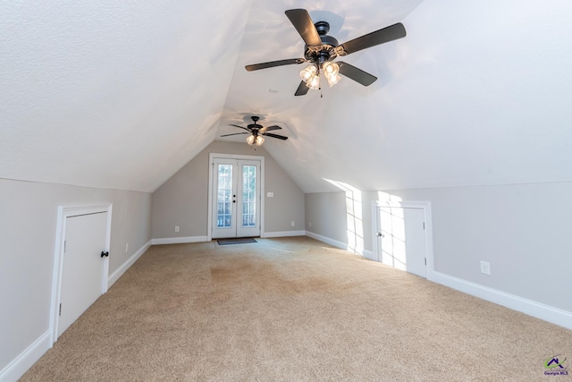 additional living space featuring ceiling fan, french doors, light carpet, and lofted ceiling