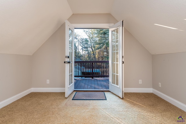 additional living space featuring light carpet and vaulted ceiling