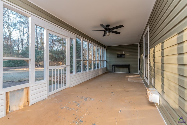 unfurnished sunroom with ceiling fan and a fireplace