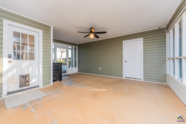 unfurnished sunroom featuring ceiling fan