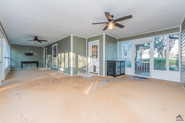 unfurnished sunroom featuring ceiling fan and a fireplace